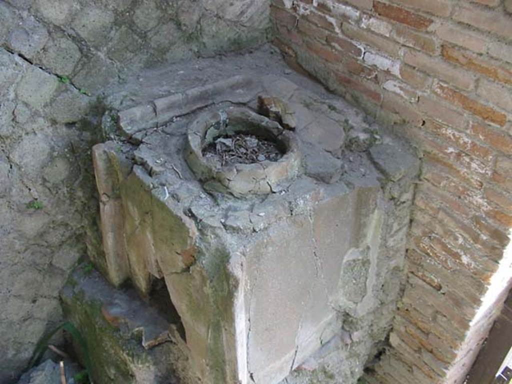 Decumanus Maximus, Herculaneum, number 8, May 2003. 
Looking towards east side of entrance doorway, and fittings for the box built with tiles. 
Photo courtesy of Nicolas Monteix.
According to Monteix, 
“Wedged, on the right, between the entrance doorway and the eastern wall, a small structure served as a support for three tiles.
The tile forming the north face is pierced by a semi-circular opening of about 30cm which would have been used as a mouth to feed the hearth.
The socket would then have served as a support for the dishes used for cooking, or even water heaters using a ceramic container.”
See Monteix, N. 2010. Les lieux de metier. Boutiques et ateliers d’Herculanum. (p.100).

Photo courtesy of Nicolas Monteix.
According to Monteix, 
“Another system, less frequently used, was employed at Herculaneum, in shop No. 8
Wedged, on the right, between the entrance doorway and the eastern wall, a small structure served as a support for three tiles.
The tile forming the north face is pierced by a semi-circular opening of about 30cm which would have been used as a mouth to feed the hearth.
The socket would then have served as a support for the dishes used for cooking, or even water heaters using a ceramic container.”
See Monteix, N. 2010. Les lieux de metier. Boutiques et ateliers d’Herculanum. (p.100)


