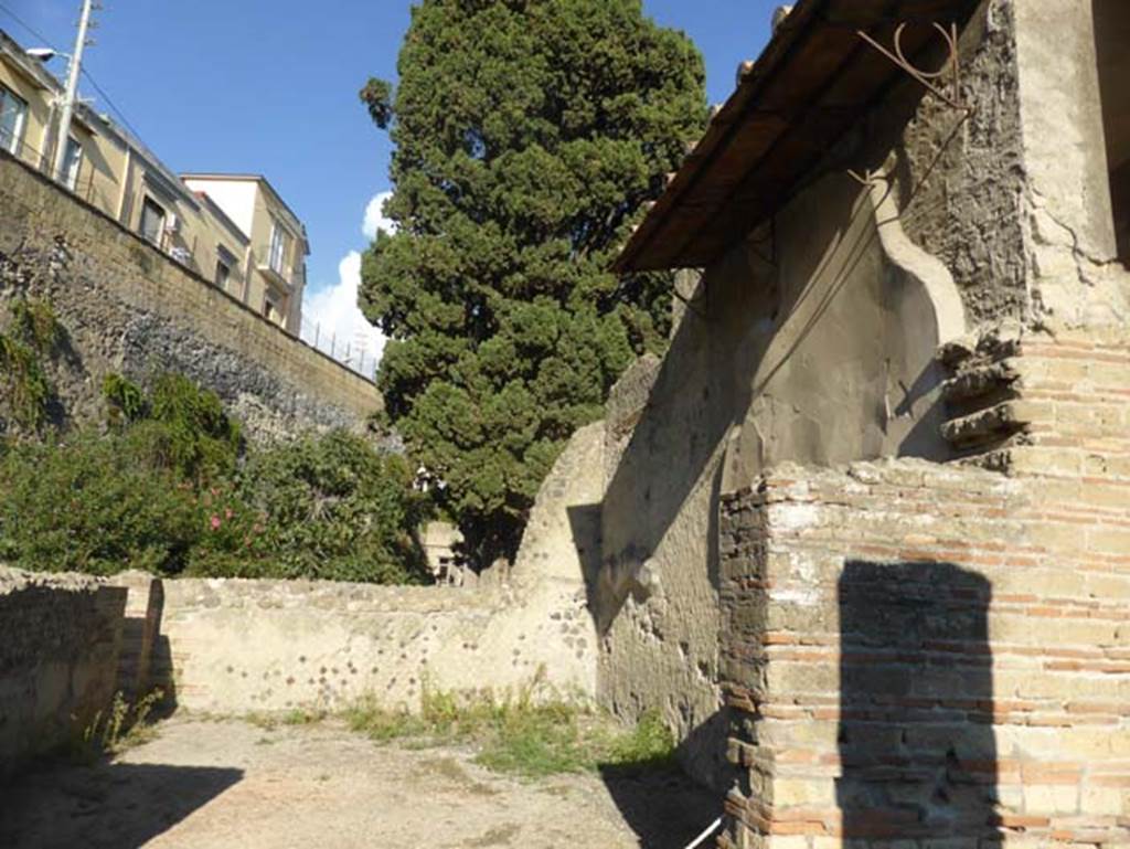 II.2 Herculaneum, September 2015. Looking towards remaining north, and east wall of rectangular exedra.
According to Barker – “In the triclinium, the pictures in the panels are larger. 
On the central panel is represented Argos and Io, from which fresco the house takes its name.
On the side panels are two winged Victories.
The frieze at the bottom is very charming, representing hunting scenes and sea monsters.
These panels are unfortunately somewhat injured.
The ground of the lower part is black, and of the upper, white”.
See Barker, E.R. (1908). Buried Herculaneum, (p.162).
