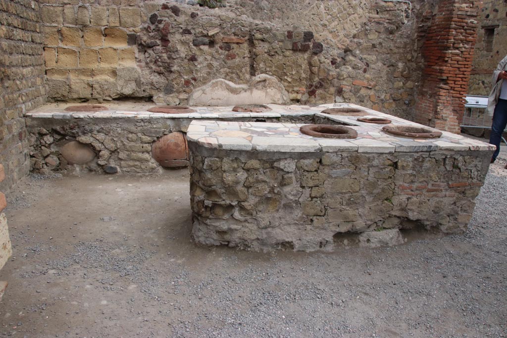 II.6/7, Herculaneum, May 2024. Looking west towards a three-sided podium. Photo courtesy of Klaus Heese.