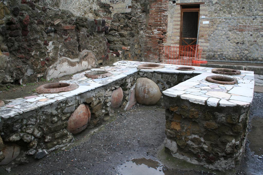 II.7/6 Herculaneum, March 2008. Looking north across counter in bar room with 7 inset dolia. Photo courtesy of Sera Baker.