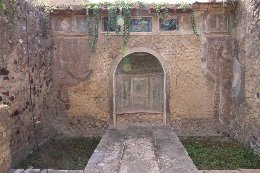 III.3 Herculaneum. September 2019. Looking towards east wall with nymphaeum, and mosaic covered frieze above.
Photo courtesy of Klaus Heese.
