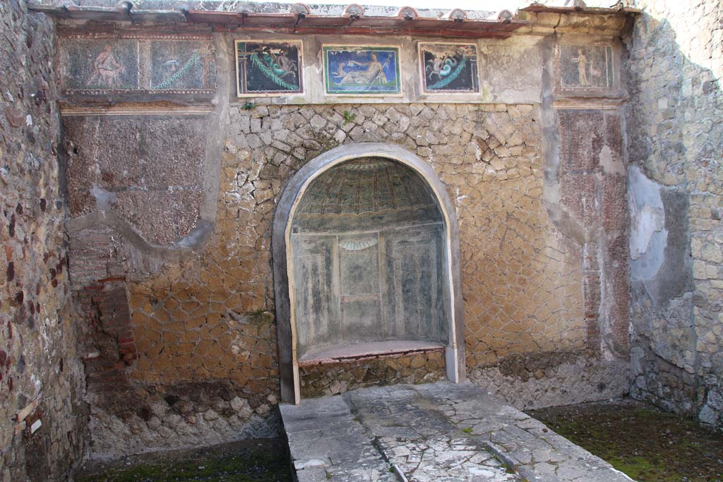 III.3 Herculaneum. April 2014. Looking towards east wall with frieze above the nymphaeum.
The central three mosaics are reproductions. Photo courtesy of Klaus Heese. 
