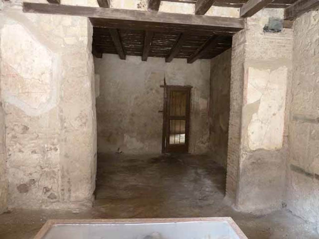 III 15, Herculaneum, May 2010. West wall of shop-room, with opening to rear room.