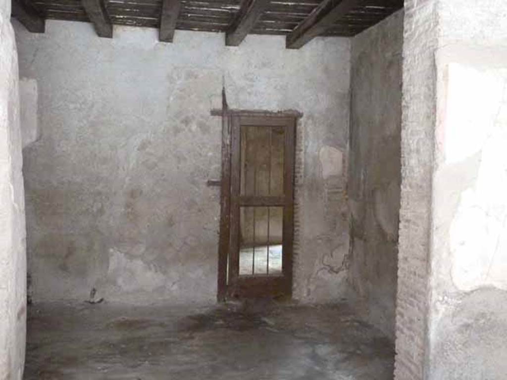 III 15, Herculaneum, May 2010. Rear room with a doorway in the west wall.
It is not certain whether this doorway led into other rooms that may have been linked to this shop and rear room, or were part of another dwelling in III.14.  (to see the rear rooms on the west side, see III.14).
