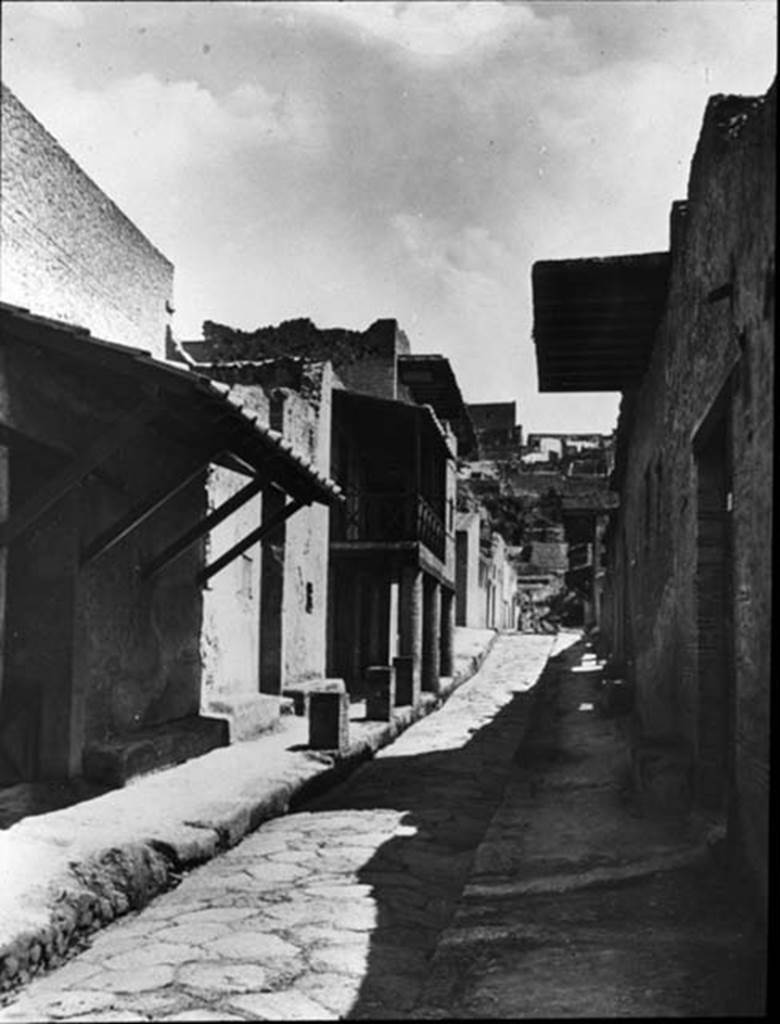 Cardo IV Inferiore, Herculaneum. 1935. Photo by Fratelli Alinari (I.D.E.A.). Alinari No 43137 (1935) oN.  Looking north from III.17, Casa dellAra Laterizia or House of the Brick Altar, on left, and IV.2, Casa dell Atrio a mosaico or House of the Mosaic Atrium, on right.  The colonnade in the centre of the photo is outside III.14, Casa a Graticcio or House of the Wattle Work (Opus Craticium),  Used with the permission of the Institute of Archaeology, University of Oxford. File name instarchbx116im013 Resource ID 42232.
