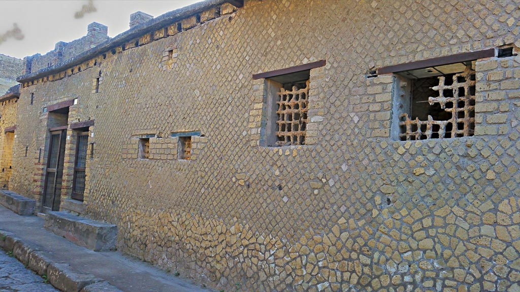 IV.4 and IV.3 Herculaneum, on left, photo taken between October 2014 and November 2019.
Looking north along front façade on east side of Cardo IV. 
Above the doorways are the remains of the holes for the support beams of a long overhanging gallery. Photo courtesy of Giuseppe Ciaramella.

