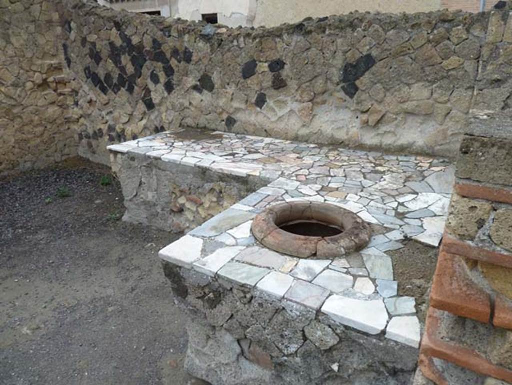 Ins. IV.10, Herculaneum, September 2015. Two side counter/podium, with one dolium set in counter.