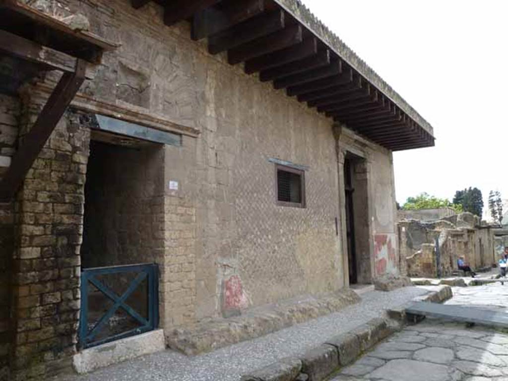 Ins. V.2 and 1 on south side of Cardo IV Superiore, at junction with Decumanus Inferiore, on right. May 2010.  According to Maiuri,
“The open gallery that overhangs the porch and runs along the whole façade is due, as is the case for the neighbouring House with the wooden screen/Casa del tramezzo di legno, to a later extension of the upper floor, when by means of the adjoining entrance at V.2 and steep wooden steps, the rooms above the main doorway were detached from the rest of the house, forming a small apartment to let”.
See Maiuri, Amedeo, Herculaneum. 7th English ed, of Guide books to the Museums Galleries and Monuments of Italy, No.53 (p.41).
