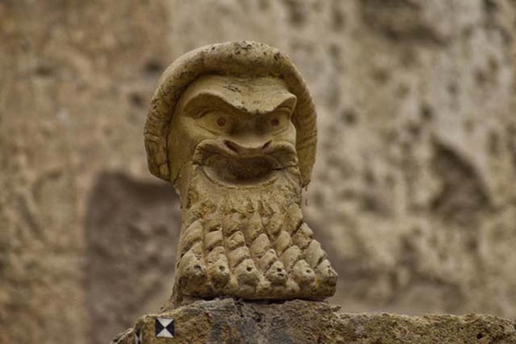 V.7, Herculaneum, April 2018. Detail of mask on north wall. Photo courtesy of Ian Lycett-King. 
Use is subject to Creative Commons Attribution-NonCommercial License v.4 International.
