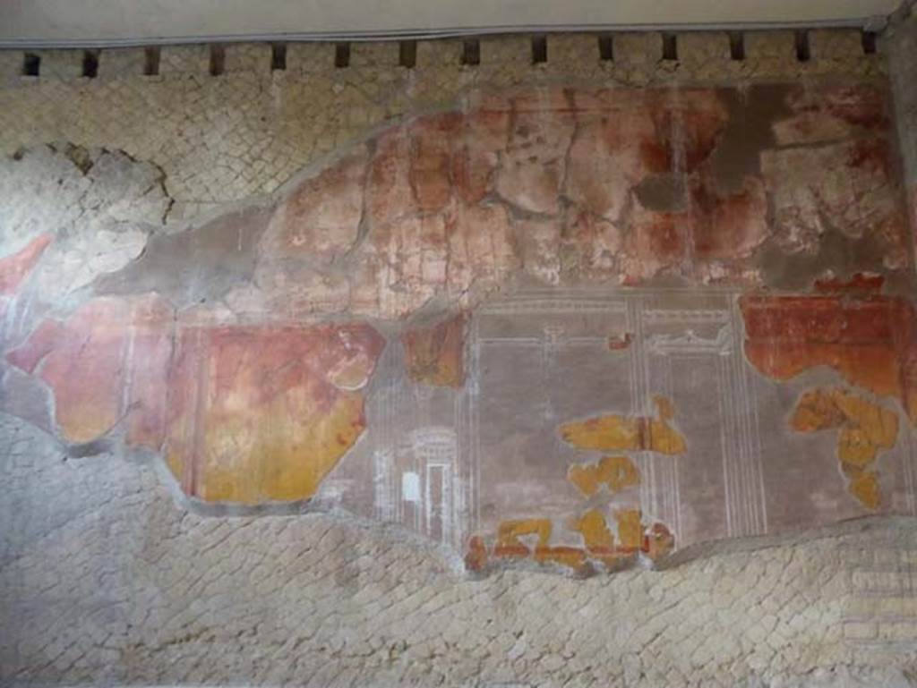 V.8, Herculaneum. October 2014. Room 7, detail from west wall. Photo courtesy of Michael Binns.  The middle areas of the walls were painted with a yellow background, this was then reddened by the heat of the volcanic surges.
