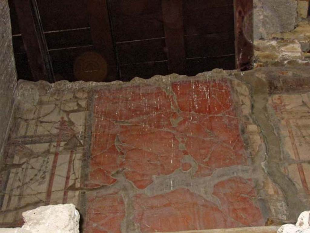 V.14/16, Herculaneum, May 2003. Room F, also known as room 8, on the upper floor, south wall of cubiculum.
Photo courtesy of Nicolas Monteix.
Maiuri described this room as – “the cubiculum F decorated with red panels sandwiched by white bands with paintings of architectural perspectives, and flanked by a corridor illuminated by a window of light corresponding to the stairwell that came upstairs from the workshop V.14”. 
