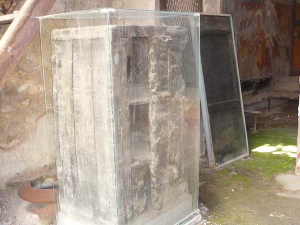 V 17, Herculaneum. May 2009. Photo courtesy of Buzz Ferebee.
Detail of cupboard/wardrobe, which was actually found in the dwelling on the upper floor at V 18.  Also found on the upper floor was part of a carbonized wooden lararium.
See Guidobaldi, M.P, (2009). Ercolano, guida agli scavi. Electa Napoli, (p.93).
See Camardo, D, and Notomista, M, eds. (2017). Ercolano: 1927-1961. L’impresa archeologico di Amedeo Maiuri e l’esperimento della citta museo. Rome, L’Erma di Bretschneider, (p.230-232, Scheda 25)
