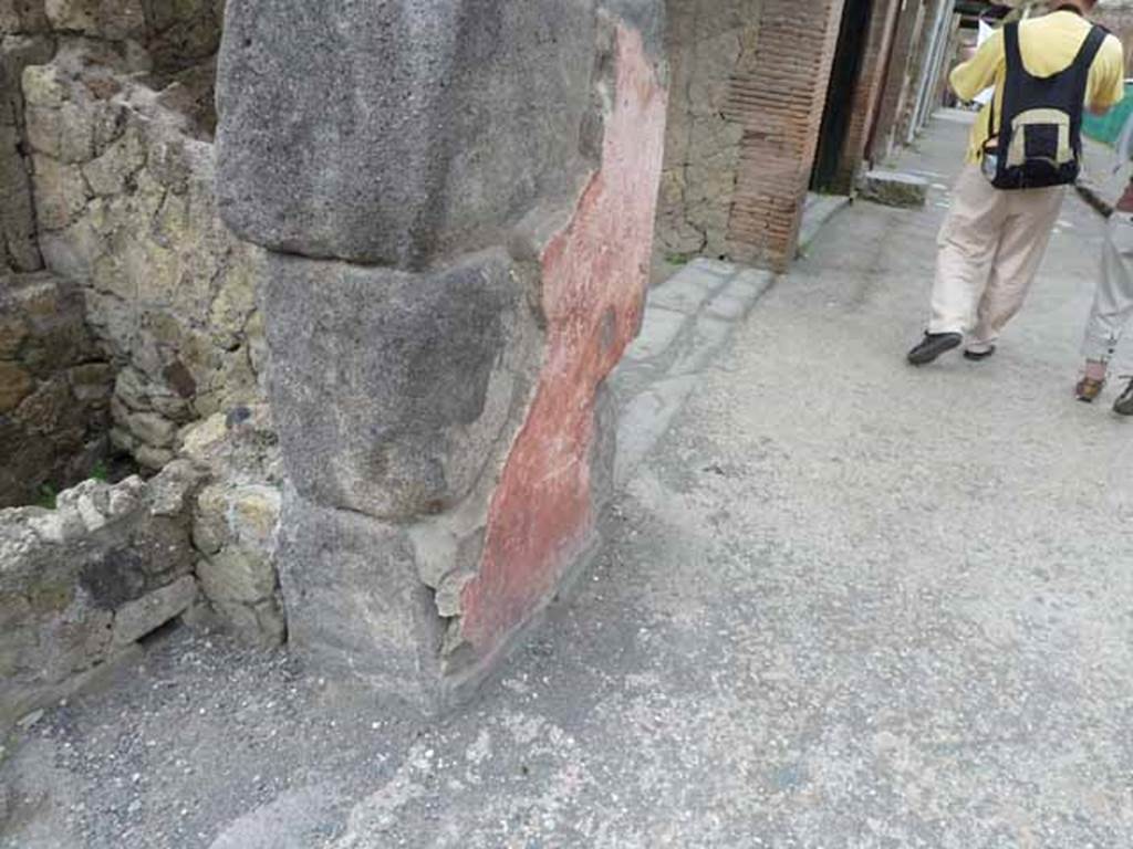 V.21, Herculaneum. May 2010. Remains of painted plaster on pilaster between V.21 and V.20 on north-east corner of insula. Looking west along Decumanus Maximus, from outside V.21.
.
