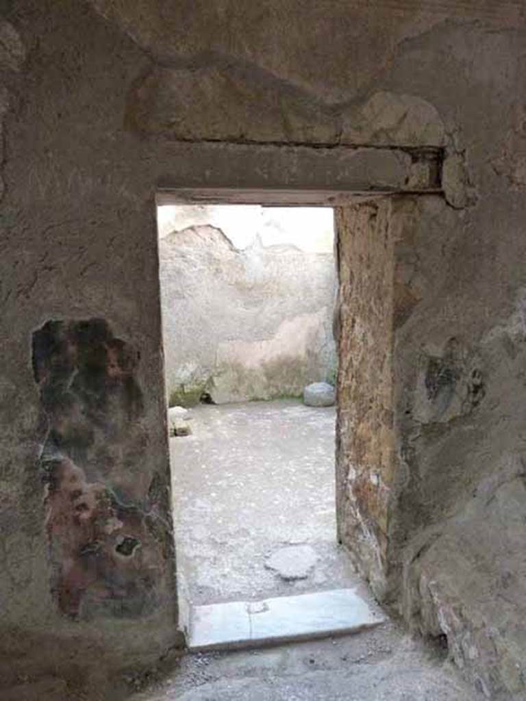 VI.1/7. May 2010. Doorway leading into the vestibule of the cold room, or frigidarium.
On the left (west side) of the apodyterium in the north-west corner is a doorway leading to the small square vestibule of the frigidarium. 
According to Maiuri, the frigidarium was painted marine blue, with red walls broken by four deep yellow niches and a domed ceiling (with a skylight) upon which is painted a fish-pond on a bluish background.
According to Guidobaldi, the water from the frigidarium would have been used to clean the latrine on its south side, at entrance VI.31.
See Guidobaldi, M.P. (2009). Ercolano, guida agli scavi, (p.100)
