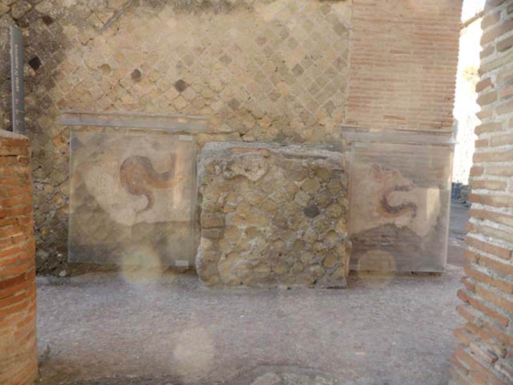 Ins VI, Herculaneum, September 2015. Looking towards east wall in north-east corner of insula, with street altar and fremains of two painted serpents.

