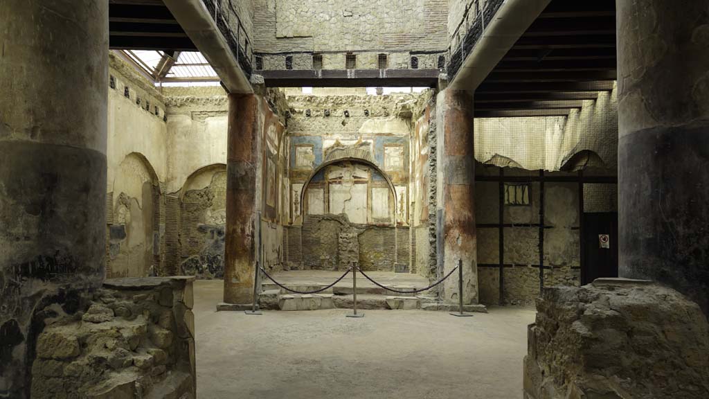 VI.21 Herculaneum. August 2021. 
Looking south towards shrine, across two statue bases between the first two columns, as you enter. Photo courtesy of Robert Hanson
