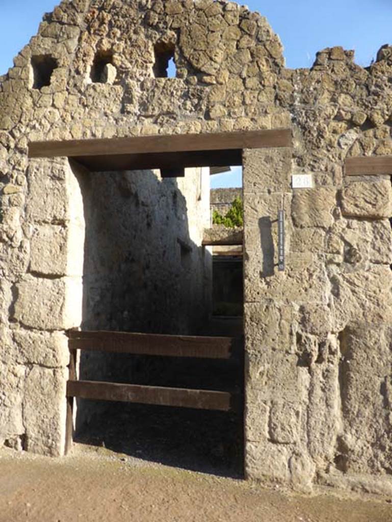 VI 26, Herculaneum, September 2015. 
Looking east on Cardo III Superiore to rear doorway to peristyle area.
Above the doorway are the holes for the support beams for an upper floor.
The main entrance would have been on Decumanus Maximus, at VI 17.

