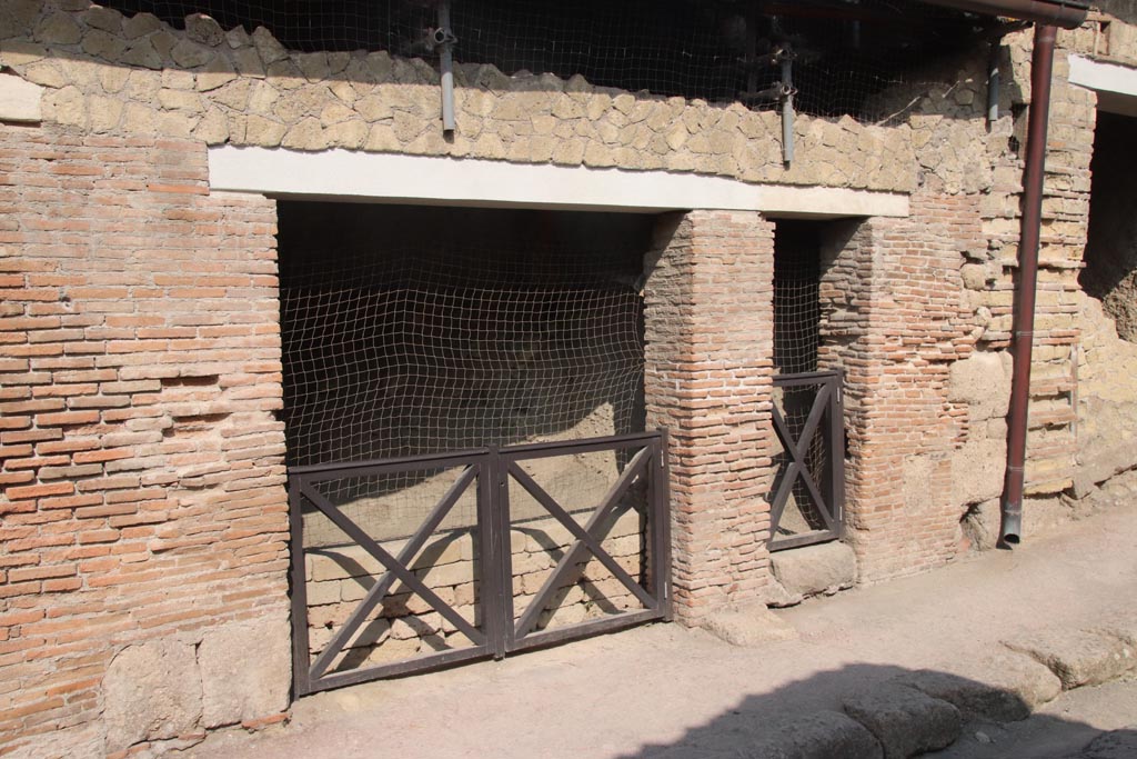 VII.10 Herculaneum. October 2023. 
Looking towards entrance doorways on west side of Cardo III, with VII.11, on right. Photo courtesy of Klaus Heese.
