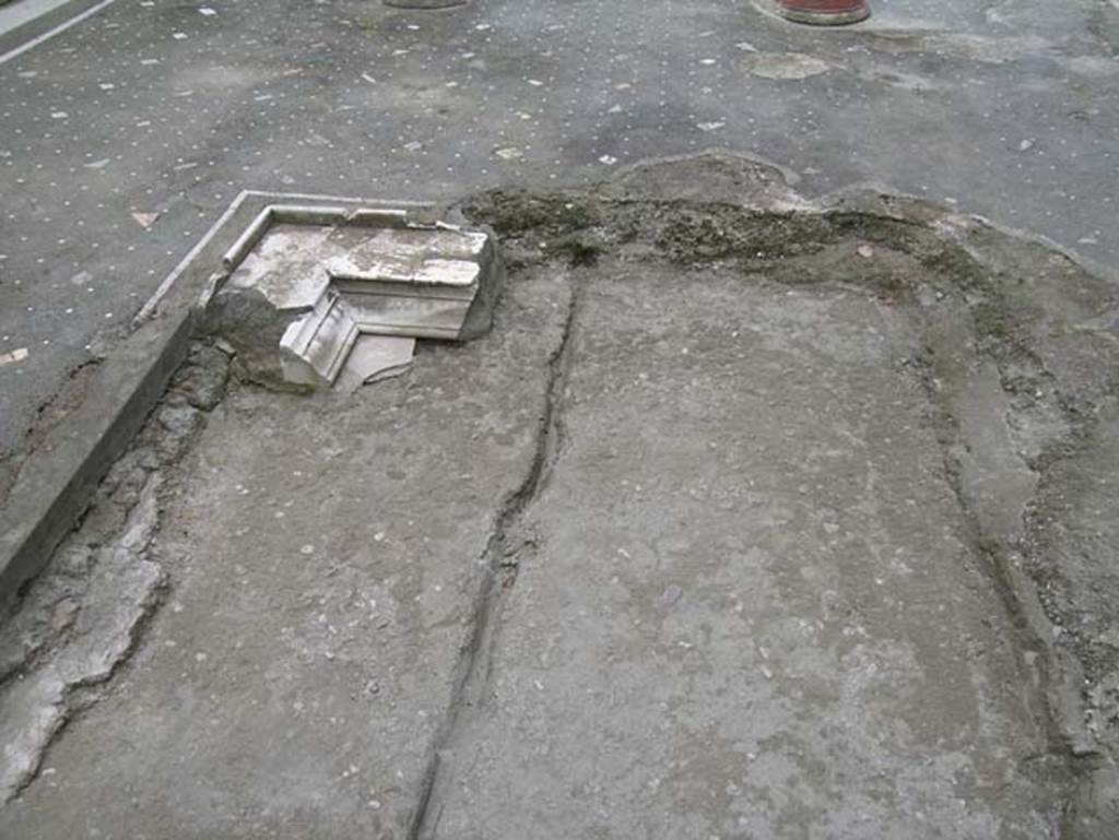 Ins. Orientalis I, 1, Herculaneum, May 2005. Looking east across impluvium in atrium.  Only one corner of the impluvium remains, covered at the edge with a fine marble cornice.
The flooring in the atrium was made from black tesserae mosaic with a simple white tesserae pattern.
Photo courtesy of Nicolas Monteix.


