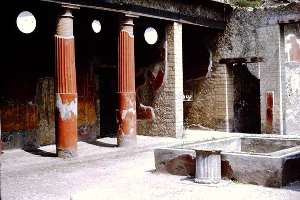 Ins. Or.I.2, Herculaneum, 1964. Looking north-east across atrium.  Photo by Stanley A. Jashemski.  Source: The Wilhelmina and Stanley A. Jashemski archive in the University of Maryland Library, Special Collections (See collection page) and made available under the Creative Commons Attribution-Non Commercial License v.4. See Licence and use details.  J64f1427
Displayed in the ala, on the north side of the atrium, a display case can be seen.
Clearly visible inside the case was one of the marble oscilla in the shape of a pelta.
See Camardo, D. & Notomista,M. (eds). (2017). Ercolano: 1927-1961. L’impresa archeologica di Amedeo Maiuri e l’esperimentodella citta museo.  Rome. “L’Erma” di Bretschneider, (p.262-3).

