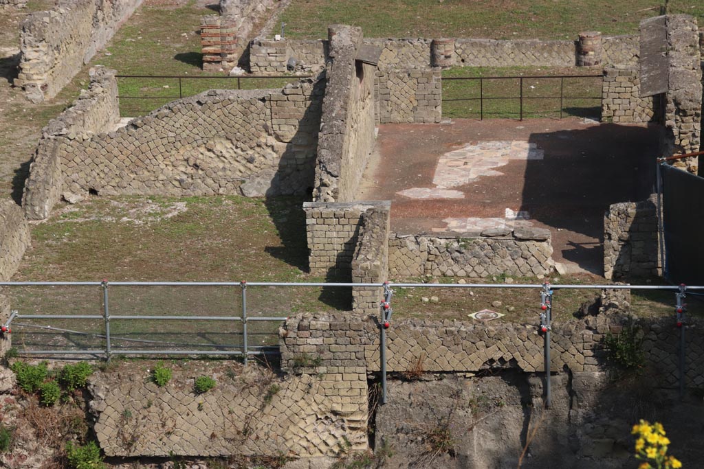 Ins. Orientalis I.2, Herculaneum. October 2023. Taken from access roadway.
Looking north towards rear room 9, on left, and rear room 10, oecus, on right, rooms on south side of peristyle.  Photo courtesy of Klaus Heese.

