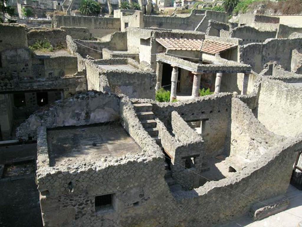 Ins.Or.II. 9/8, Herculaneum. May 2006. Looking west from upper floor of Palaestra block, above bakery, towards Insula V on Cardo V.
The doorway to V.31, Casa del Sacello di legno (House of the Wooden Lararium) is on the left, and V.30, Casa dellAtrio corinzio (House of the Corinthian Atrium) is on the right. Photo courtesy of Nicolas Monteix.
