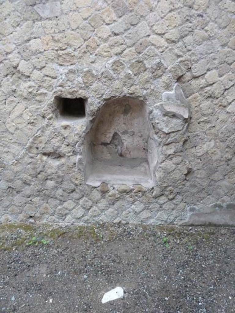 Ins. Orientalis II.10, Herculaneum. September 2015. Lararium niche in north wall of kitchen.
Found to the right of the niche was a graffito, but which has been lost.

According to Cooley and Cooley, it read -
11 September, for a tunic: 1 denarius, 7 asses.   (CIL IV 10664)

This may record the price of purchasing, or perhaps of cleaning a tunic. The graffito was found low down on an interior wall of a shop.
See Cooley, A.E, and Cooley, M.G.L. (2014). Pompeii and Herculaneum, a sourcebook. Oxon, Routledge, (p.240 numbered as H28 Expenditure on a tunic, Herculaneum ins or II.10)

Also found nearby was an altar to Hercules. 
Hercules (AE (1980) 250).

A tufa altar, 13 centimetres high, dedicated to Hercules was found in Ins. Or.II.10. It illustrated the presence of non-domestic gods in private space.
See Cooley, A.E, and Cooley, M.G.L. (2014). Pompeii and Herculaneum, a sourcebook. Oxon, Routledge, (p.150-51, numbered as E74).
