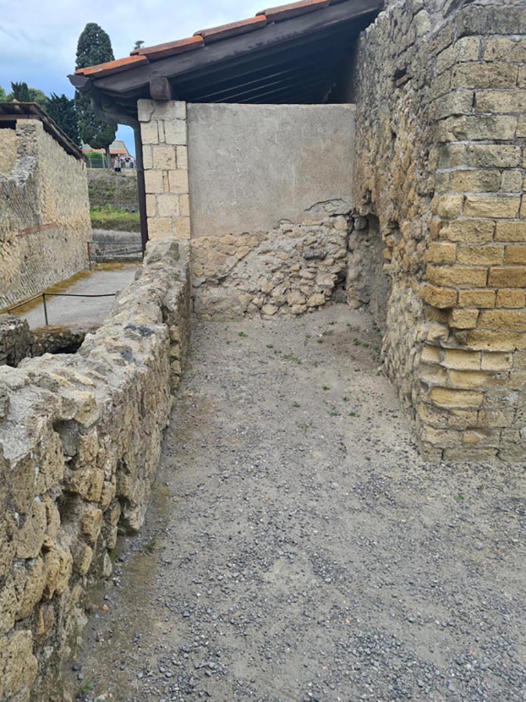 III.19/18/1 Herculaneum, May 2024. 
Looking south towards our room 7, or room (a), “porter’s room” in south-east corner of atrium.
Photo courtesy of Klaus Heese.
According to Maiuri –
“A sinistra, il piccolo vano (a), tutto aperto sul vestibolo, doveva servire da cella ostiaria (vi si nota sulla parete di fondo la nicchietta di un larario a poco altezza dal pavimento e, sulla parete di lato l’incassatura per il letto)”.
(On the left, the small room (a), all open onto the vestibule, which must have served as “cella ostiaria” (the room of the porter). 
On the rear wall you can see the niche of a lararium, a little height from the floor and, on the side wall, the recess for the bed).
See Maiuri, A., 1958. Ercolano, I Nuovi Scavi, (1927-1958). Vol.1. Roma: Inst. Poligrafico dello Stato, (p.325).

