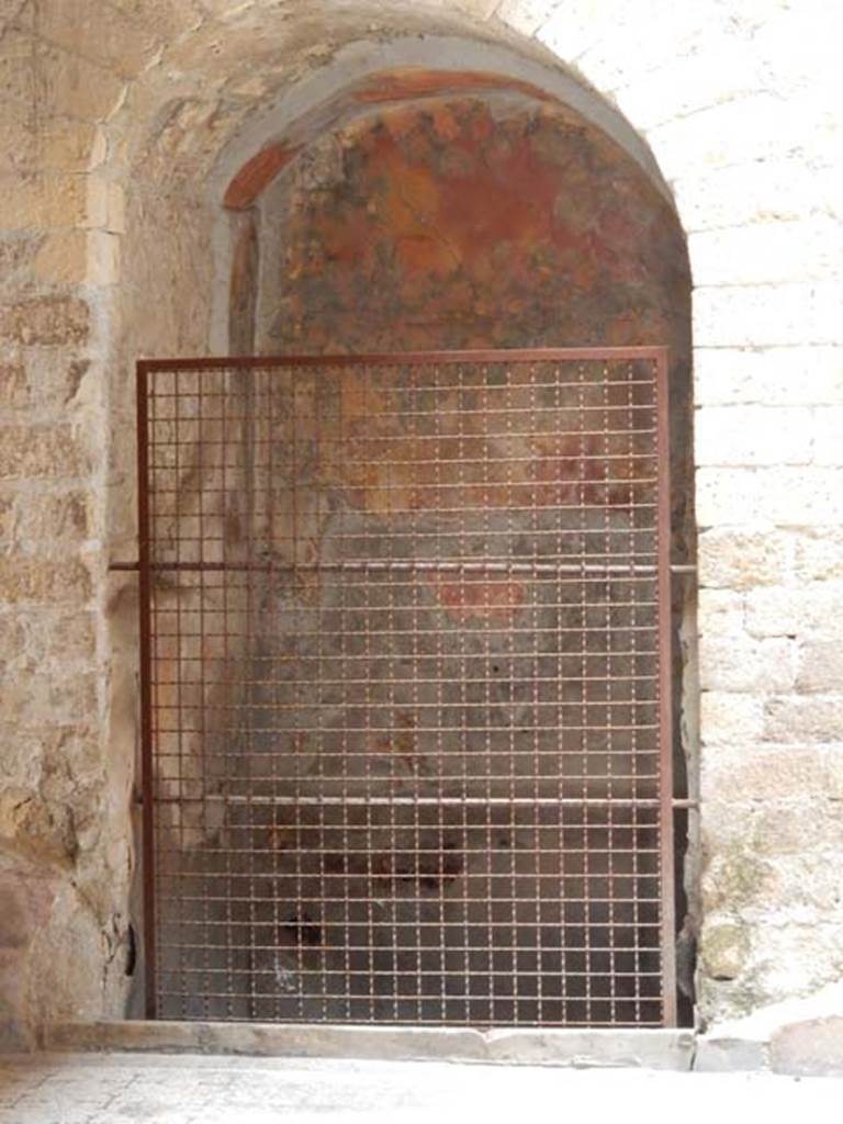 V.8 Herculaneum, May 2018. Area 4, arched recess under stairs. Photo courtesy of Buzz Ferebee.
According to Maiuri –
“Con la sua scala in muratura alleggerita dalla nicchia arcuata del rampante entro cui è ricavata la bocca del pozzo……”
L’arcata del pozzo nel sottoscala appare dipinta e decorata come un sacello; cespi fronzuti e fioriti di oleandri ai lati e tralci di pampini di vite riempiono le pareti della nicchia con la stessa fresca naturalezza di colore della parete di un viridario.” 
("With its masonry staircase relieved by the tilted arched niche within which the well mouth is cut......"
The archway of the well under the stairs appears painted and decorated like a sacellum; leafy, flowering bushes of oleander on either side and vine shoots fill the walls of the niche with the same freshness of colour as the wall of a viridarium.")
See Maiuri, A., 1958. Ercolano, I Nuovi Scavi, (1927-1958). Vol.1. Roma: Inst. Poligrafico dello Stato, (p.387).
