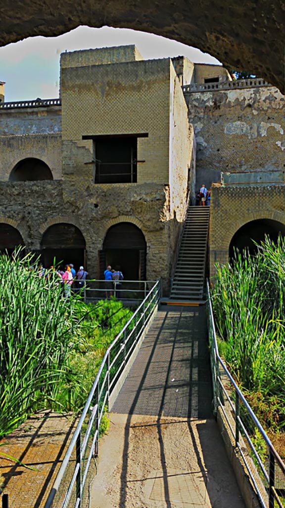 Herculaneum. Photo taken between October 2014 and November 2019.
Looking north from exit tunnel across bridge across beachfront area towards boatsheds and steps to terrace of Balbus. 
Photo courtesy of Giuseppe Ciaramella.

