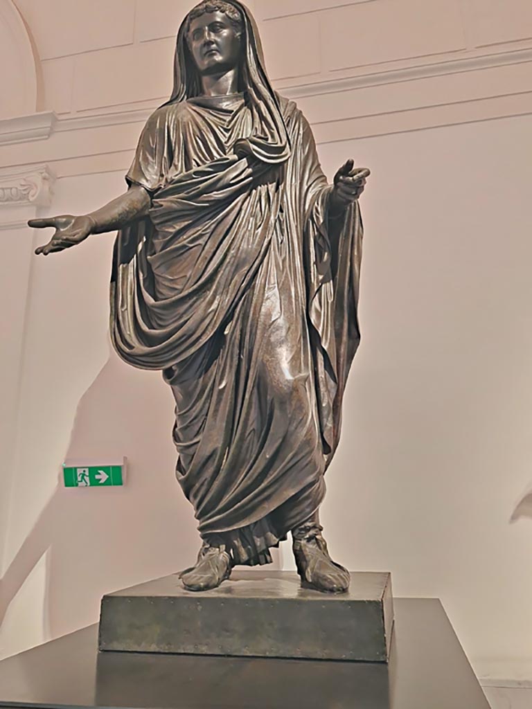 Herculaneum Theatre. April 2023. 
Detail of bronze statue of Tiberius, inv. 5615. Photo courtesy of Giuseppe Ciaramella.
