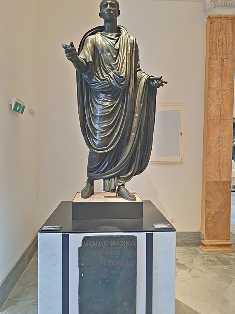 Herculaneum theatre. April 2023. 
Above - Bronze statue of Lucius Mammius Maximus, inv. 5591.
Below – Bronze plaque with dedication to Lucius Mammius Maximus, inv.3748.
On display in “Campania Romana” gallery in Naples Archaeological Museum. Photo courtesy of Giuseppe Ciaramella.

