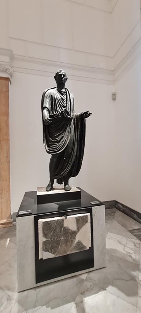 Herculaneum theatre. April 2023. 
Above - Bronze statue of Marcus Calatorius Quartio, inv. 5597.
Below – Dedication on marble slab, inv. 3730. 
On display in “Campania Romana” gallery in Naples Archaeological Museum. 
Photo courtesy of Giuseppe Ciaramella.
