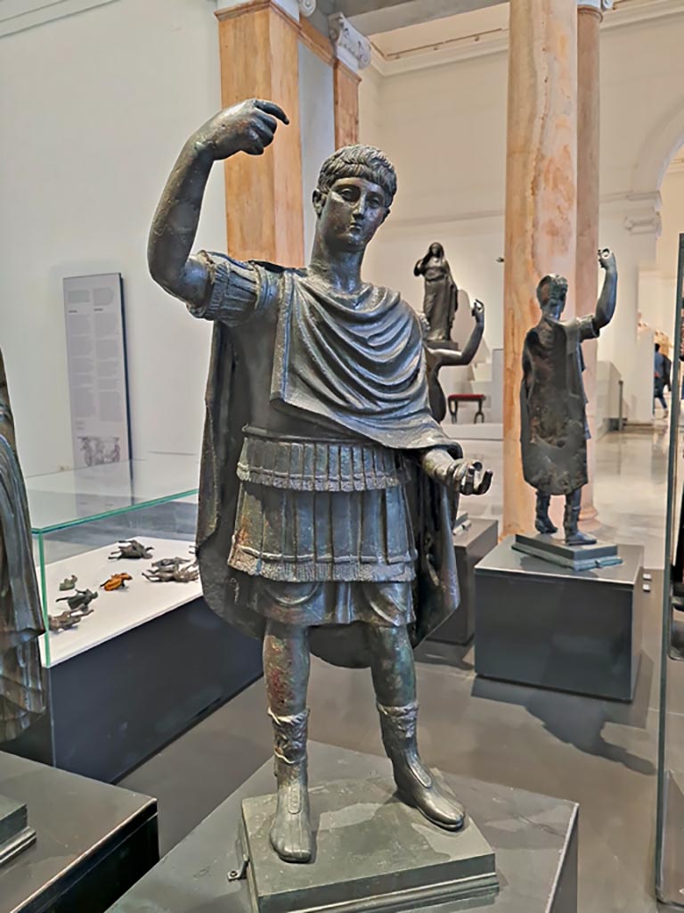 Herculaneum, April 2023. 
Detail of small bronze military style figure used to decorate the box of the chariot. 
Now on display in “Campania Romana” gallery in Naples Archaeological Museum. Photo courtesy of Giuseppe Ciaramella.

