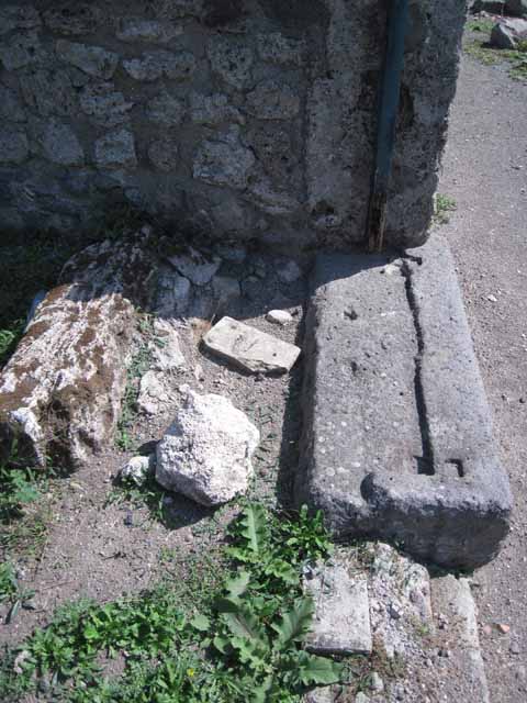 I.1.8 Pompeii, on left, and I.1.7 Pompeii, stairs to upper floor, on right. September 2005.
According to Warscher, quoting Mau in Bull.Inst 1875, p.30, I.1.6-9: “Segue un altro albergo, molto simile a questo descritto.  Qui pure è interrotto il marciapiede per lasciar entrare i legni. L’entrata era chiuse mediante una porta a quattro partiti, congiunti a due adue, come si conosce dai quattro buchi per i chiavistelli.  Qui pure si entra prima in un compreso che ha le dimensioni d’una bottega grande con una dietrobottega e posteriormente si apre sopra una grande corte, lungo il cui muro di fondo qui pure si stende la stalla, larga 13,30, profonda 2,47 con una finestra sul vico settentrionale e due porte, una all’estremità meridionale, l’altra poco distante da quella settentrionale. 
Presso a quest’ultima una parte della corte è selciata.  Lungo il muro N vi sono due camere con finestre sul medesimo vico, e prossimo alla stalla il cesso.  Si vede anche il cesso del piano superiore e i tubi di mattone d’un terzo, che stava ancora più in alto.  
Nell’angolo NO vi sono I primi gradini d’una scala, la cui parte superiore sarà stata di legno, in quello SO l’apertura della cisterna, e accanto nella stessa massa di materiale una vasca lunga stretta e bassa, come quella sudescritta nella casa adiacente. Qui la vediamo frapposto fra la cisterna ed il muro di O, il che esclude categoricamente l’aver essa servito d’abbeveratoio. Dalla parte più bassa di essa, aperta come nella casa sudescritta, l’acqua colava in un’altra vasca larga 1,02 x 1,54, di cui un lato viene formato dalla suddetta massa di fabbrica, uno dal muro occidentale, i due rimanenti da appositi muricciuoli.  Essa ha al fondo uno scolo verso N, che dà in un vaso ossia tubo di mattone, incastrato nel suolo. Nella parete vi era la pittura dei Lari, di cui sono rimasti soltanto i serpi. A destra dell’ingresso per i legni sta un locale come una bottega. 
L’essere esso congiunto mediante una porta con quel primo compreso, ove entravano i legni, ci lascia supporre, aver esso servito di caupona per i vetturini”.
See Warscher T., 1935. Codex Topographicus Pompeianus: Regio I.1/I.5. Rome: DAIR. (no.14)
(for a translation see, I.1.6).

