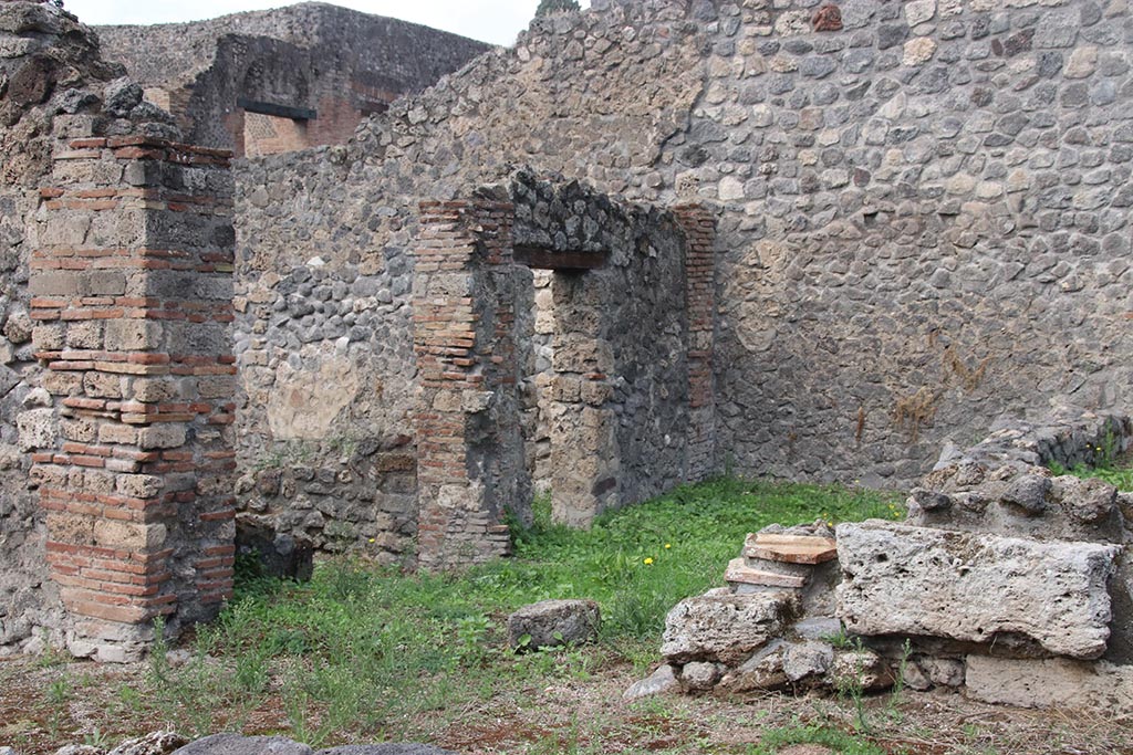 I.2.31 Pompeii. September 2010. Looking north to entrance doorway (cill or threshold still there). The green grassed area would have been one rear room of the bar at I.2.1. The other rear room would have been where the scaffolding is now. Photo courtesy of Drew Baker.
