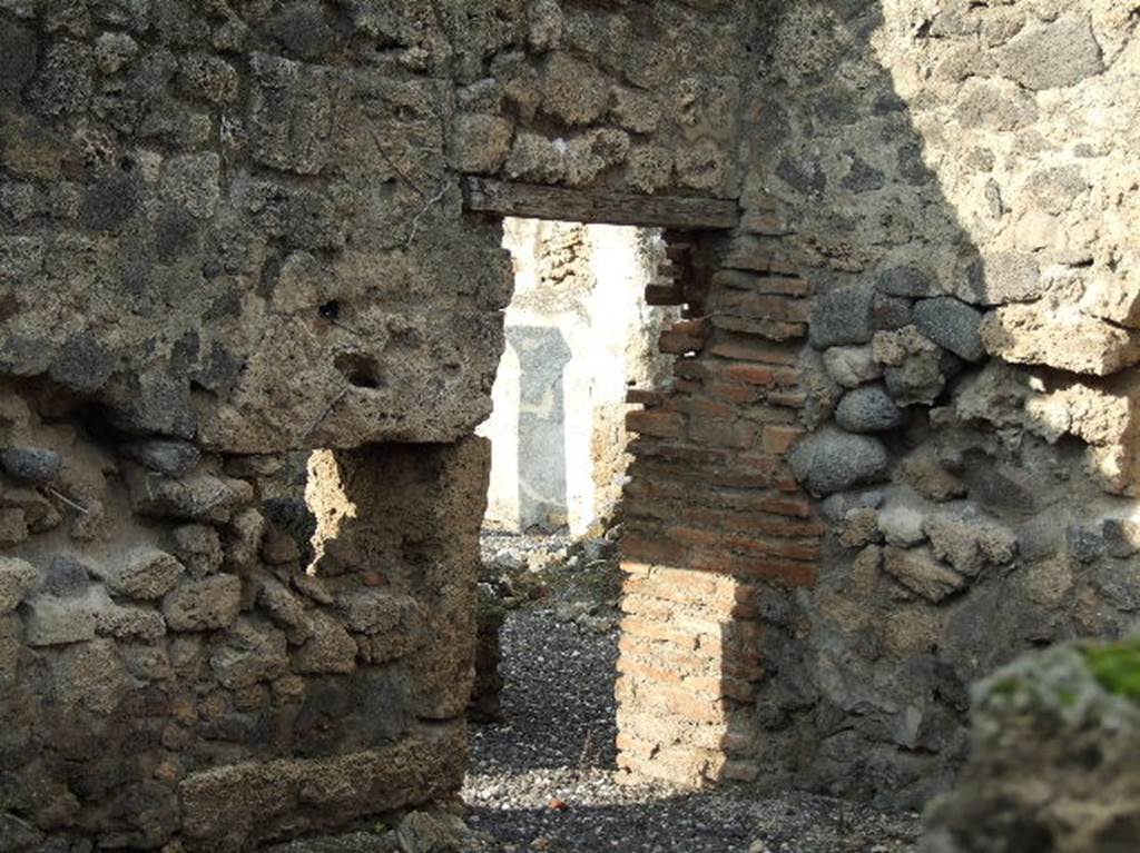 I.3.8b Pompeii. December 2006. Looking west through doorway in north-west corner of kitchen on east side of property, through hole in wall from I.3.25