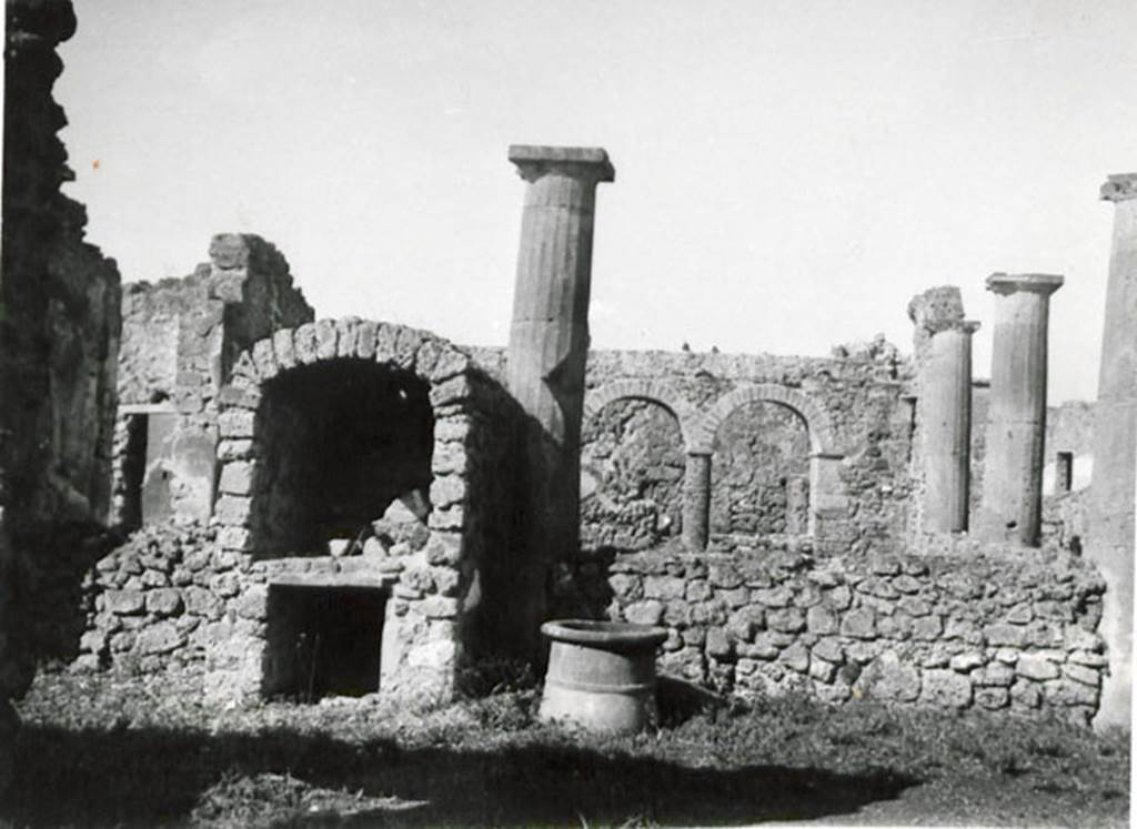 I.3.8b Pompeii. 1935 photograph taken by Tatiana Warscher, taken from the east. 
See Warscher, T, 1935: Codex Topographicus Pompejanus, Regio I, 3: (no.16a), Rome, DAIR, whose copyright it remains.  
According to Warscher, 
“This house was not without interest. The tufa Doric columns of the peristyle had been joined – later – by a wall between them. The west side of the portico consisted of brick columns surmounted by arches. Above these arches was a walkway. The north wall ended in a vault.”
