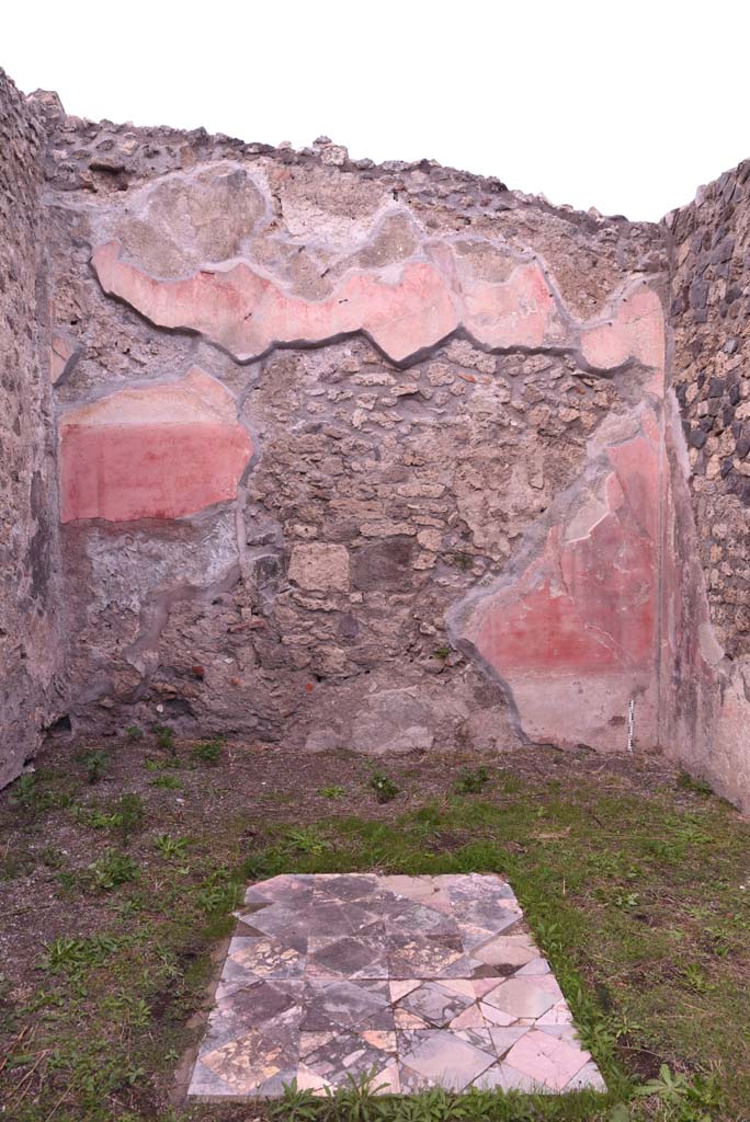 I.4.9 Pompeii. October 2019. Triclinium/oecus m, north wall.
Foto Tobias Busen, ERC Grant 681269 DCOR.
According to PPM 
The north wall was perforated by explorers penetrating the house in search of materials useful for reconstruction after the eruption of 79AD, of the central aedicula in the rear wall only the triangular tympanum remained, which rises up to the upper red area punctuated by slender architectures.
With regard to the flooring, the position of the table in the middle of the three couches in the triclinium was given this carpet of squares and triangles of coloured marble. (1977).
See Carratelli, G. P., 1990-2003. Pompei: Pitture e Mosaici. I. Roma: Istituto della enciclopedia italiana, (p. 180).
