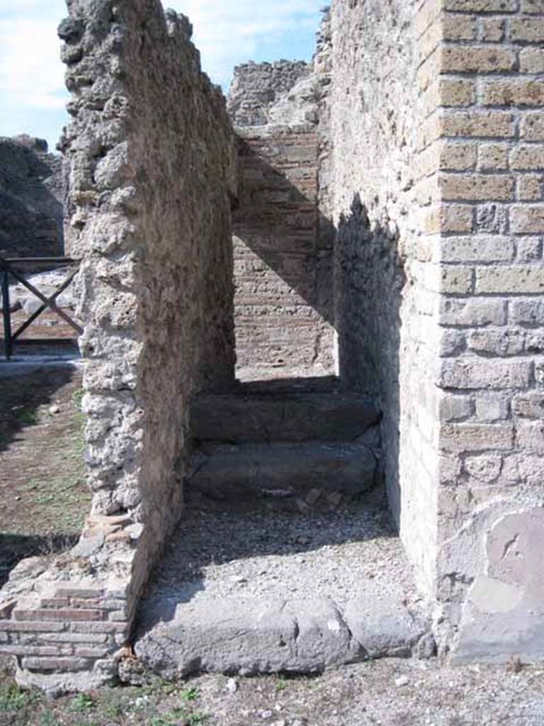 I.5.2 Pompeii. September 2010. Looking north towards steps to upper floor, with remaining two stone steps. Note doorway on east wall of shop-room leads under this stairway. Photo courtesy of Drew Baker.

