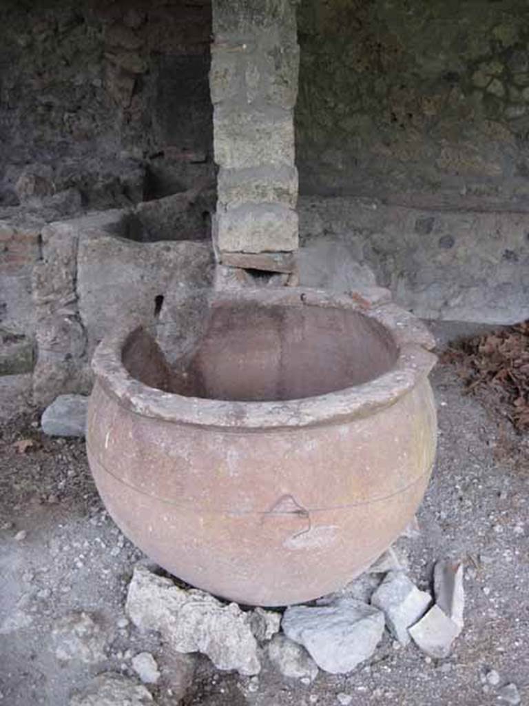 I.5.2 Pompeii. September 2010. Front on view of the dividing bay wall showing discharge pipe into pot. Photo courtesy of Drew Baker.
