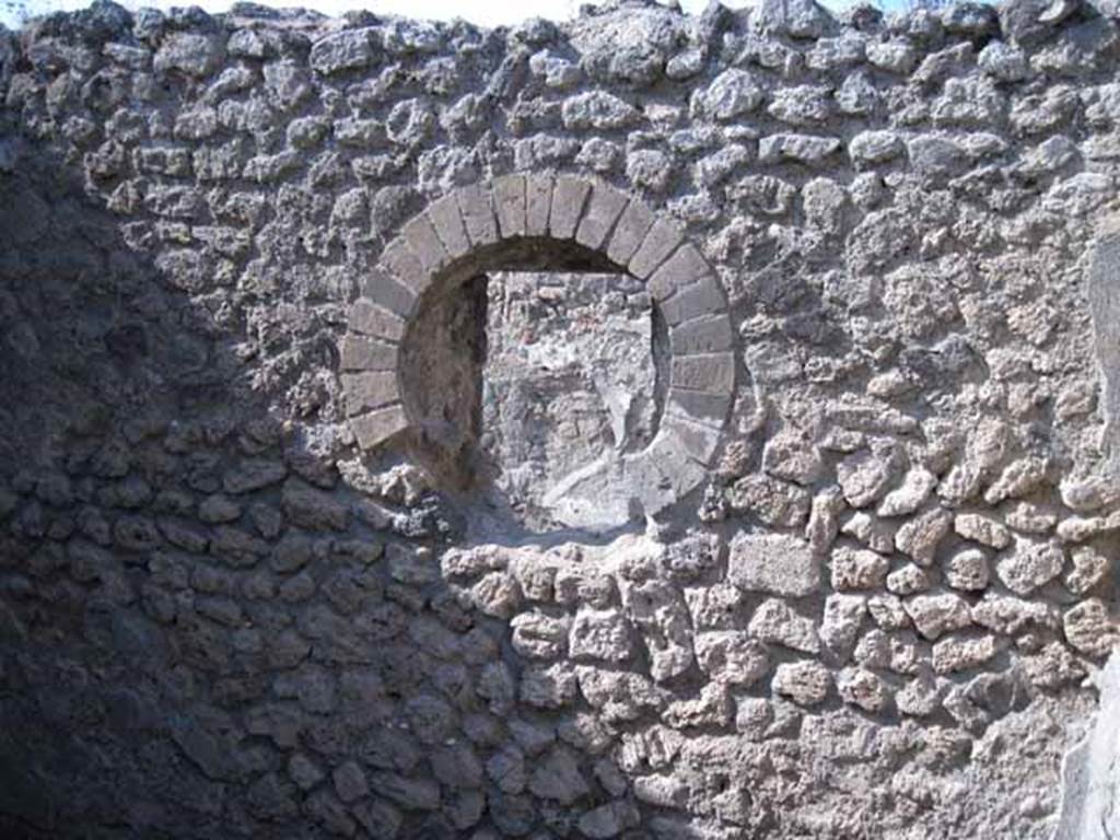 I.5.2 Pompeii. September 2010. Round window in north wall, looking onto Vicolo del Conciapelle. Photo courtesy of Drew Baker.
