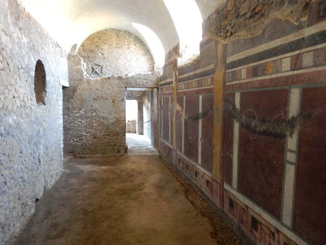 I.6.2 Pompeii. May 2006. Anteroom, apodyterium or changing room on south side of frigidarium, at end of corridor. Looking west towards arched entrance to area under stairs, and doorway into passage leading to east wing of cryptoporticus. The arched doorway into the frigidarium can be seen in the north wall, on the right side. According to Peters, on the north and south walls of the passageway, badly preserved landscapes were found. See Peters, W.J.T. (1963): Landscape in Romano-Campanian Mural Paintings.The Netherland, Van Gorcum & Comp. (p.23)