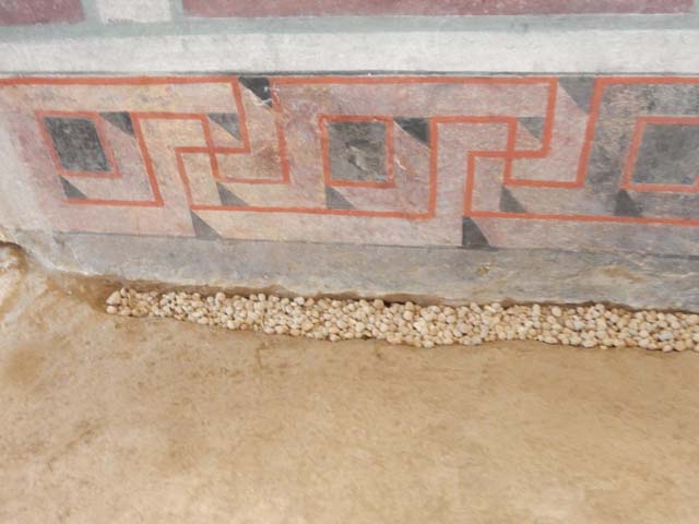 I.6.2 Pompeii. May 2006. Frigidarium, north wall. Detail of upper centre. According to Peters, this shows a tripod on a base with relief, against a background of trees. He said the relationship between the tripod and Apollo was a well-known one. See Peters, W.J.T. (1963): Landscape in Romano-Campanian Mural Paintings.The Netherland, Van Gorcum & Comp. (p.24 and fig.13).