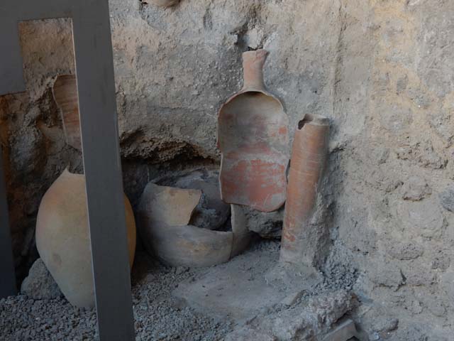 I.6.7 Pompeii. May 2016. Looking south-east towards east end of kitchen showing base of downpipe, and pots. Photo courtesy of Buzz Ferebee.
