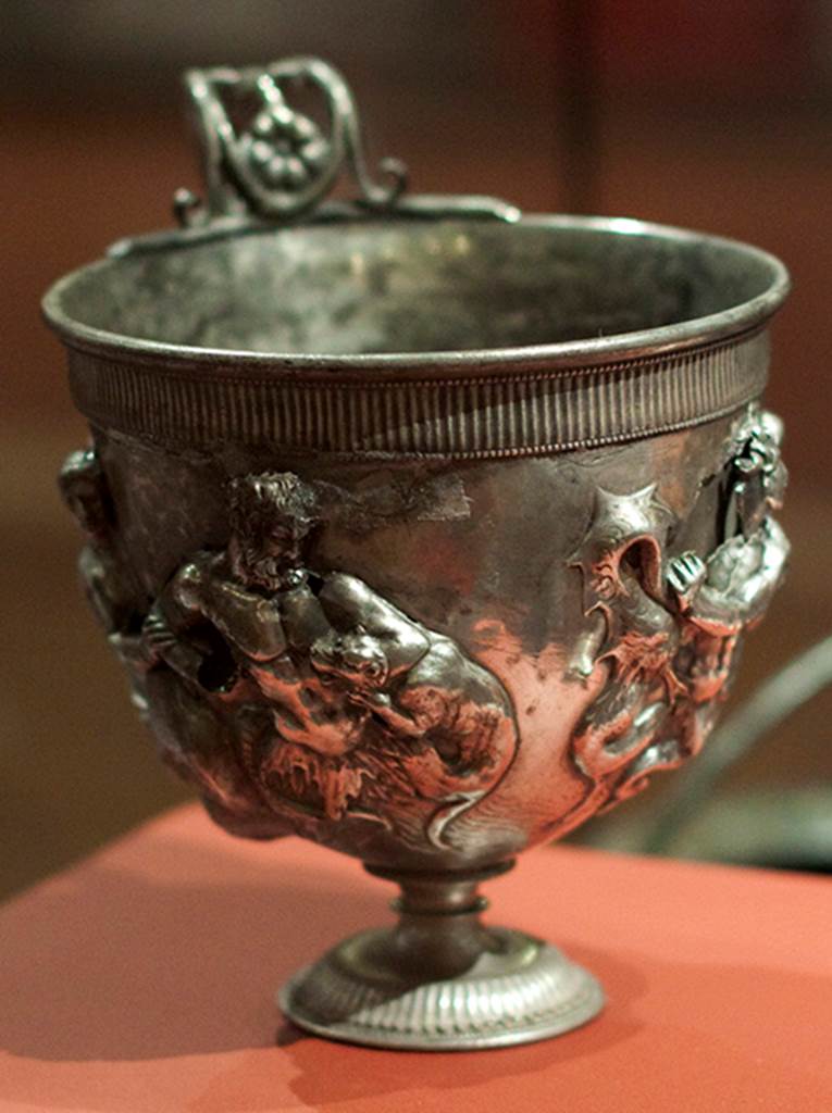 Silver found against west wall of atrium of I.6.11. 
Single handled kantharos or drinking cup decorated with Tritons and Nereid. 
Now in Naples Archaeological Museum.  Inventory number 144802. See Guzzo, P. (A cura di), 2006. Argenti a Pompei. Milano, Electa. p.140.
