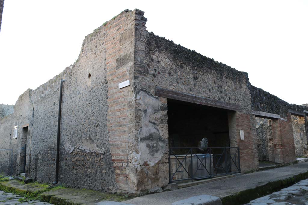 I.8.9 Pompeii, in the side roadway on left, and I.8.8, entrance doorway, in centre. December 2018. 
Looking west along Via dell’Abbondanza. Photo courtesy of Aude Durand.
