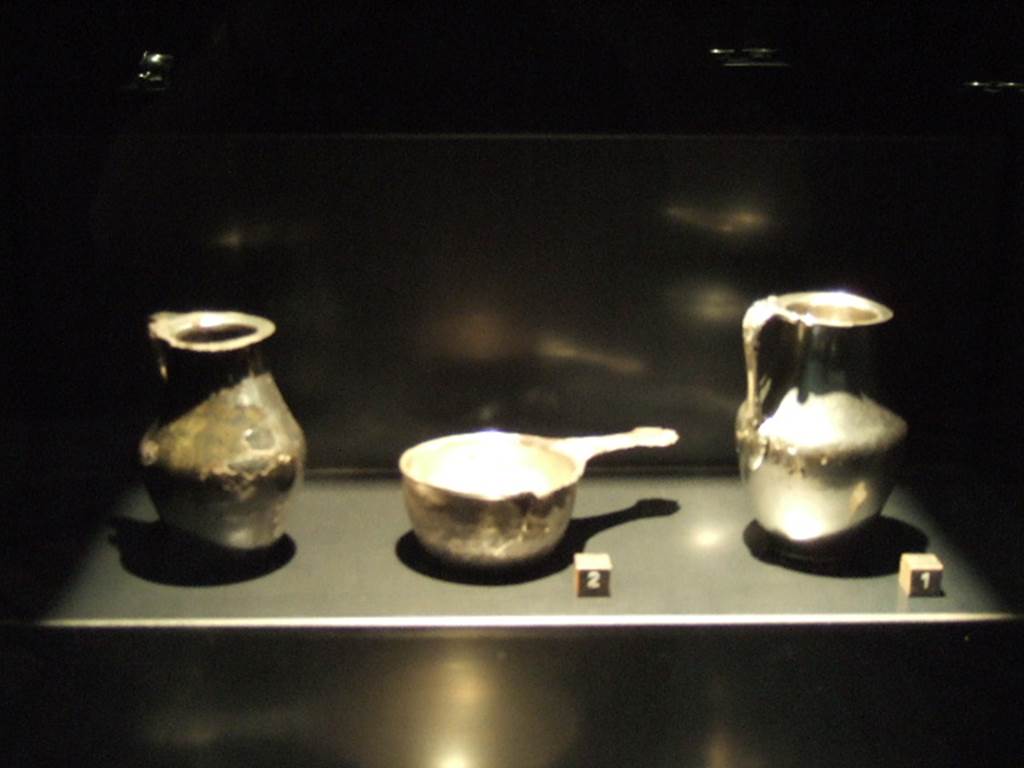 I.8.14 Pompeii. Silver found in the vestibule, probably kept in a wooden box. Jug - SAP inventory number 7478, a patera - SAP inventory number 7482 and jug - SAP inventory number 7477. See Guzzo, P. (A cura di), 2006. Argenti a Pompei. Milano, Electa. (p. 148 and 150).