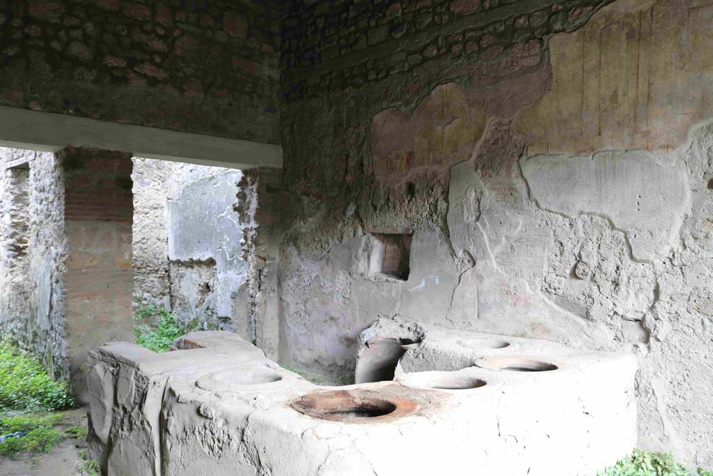 I.8.15 Pompeii. May 2003. Looking towards east wall with niche, and broken dolium set in counter below. Photo courtesy of Nicolas Monteix.


