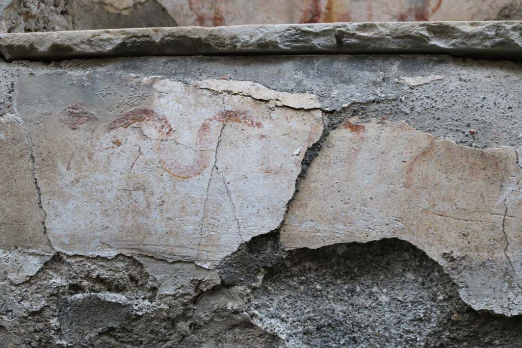 I.10.3 Pompeii. December 2018. Painted serpent below the niche on east wall of fauces. Photo courtesy of Aude Durand.